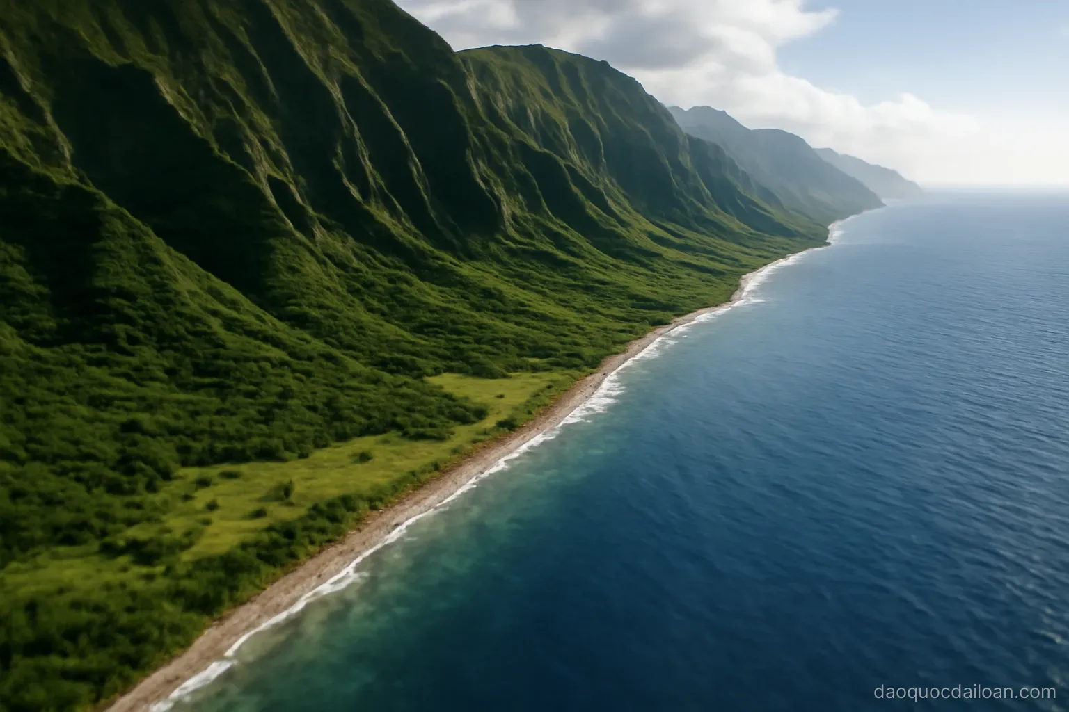 A narrow strip of flat land between towering green mountains and a deep blue ocean, aerial perspective, no readable text